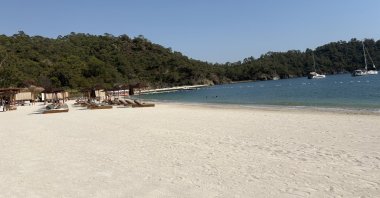 People sunbathe on the beach at Ahãma in Günlüklü Bay, Göcek, Muğla, southwestern Türkiye, July 17, 2025. (Courtesy of Funda Karayel)
