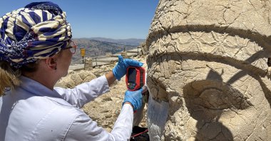 A restoration worker applies a nano-dispersed calcium hydroxide solution to an iconic sculpture at Mount Nemrut, southeastern Türkiye, July 15, 2025. (AA Photo)