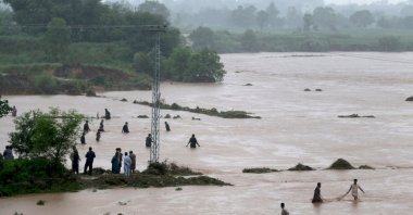 Local people catch fish in the floodwaters during heavy monsoon rains at the Ladian village in Rawalpindi, Pakistan, July 17, 2025. (EPA Photo)
