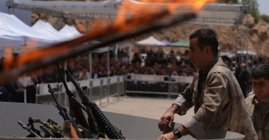 The first group of PKK terrorist members place their weapons into a cauldron to be burned, Sulaymaniyah, northern Iraq, July 11, 2025. (AA Photo)
