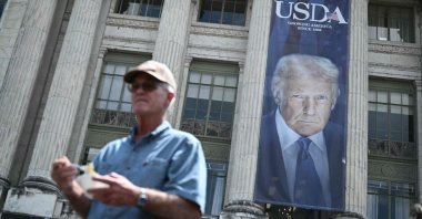 A man holds a bowl of ice cream following during a news conference with US Secretary of Health and Human Services Robert F. Kennedy Jr., as an image of U.S. President Donald Trump hangs outside the USDA headquarters building in Washington, DC, U.S., July 14, 2025. (AFP Photo)