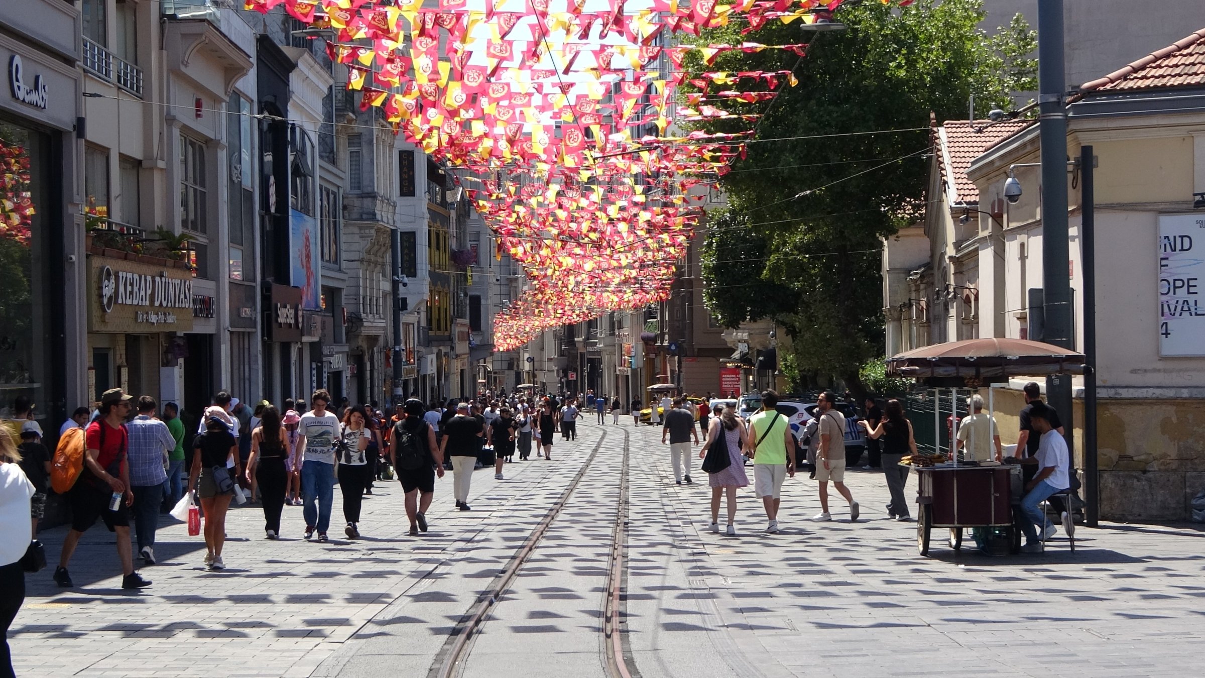 People walk along the Istiklal Avenue, one of the main shopping streets in Istanbul, Türkiye, July 17, 2025. (IHA Photo)