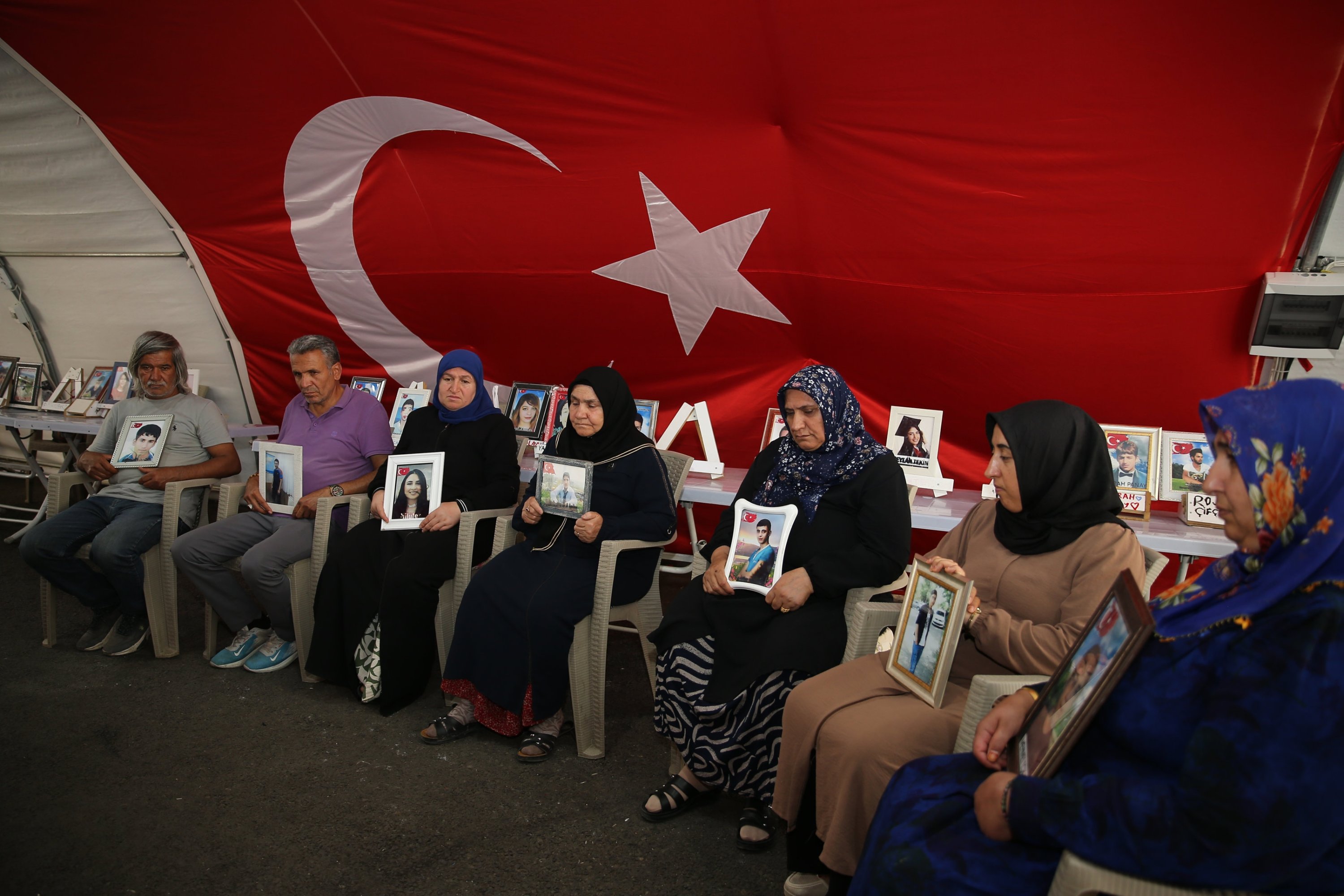 تتجمع العائلات ، التي تحمل صورًا لأطفالهم التي اختطفها حزب العمال الكردستاني ، خارج المكتب المحلي لحزب المساواة والديمقراطية في الشعوب (DEM) ، حيث يحل حزب العمال الكردستاني وينتهي من تمرد توركياي لمدة 40 عامًا ، دييارباكير ، تورركي ، 11 يوليو 2025. (صورة AA)