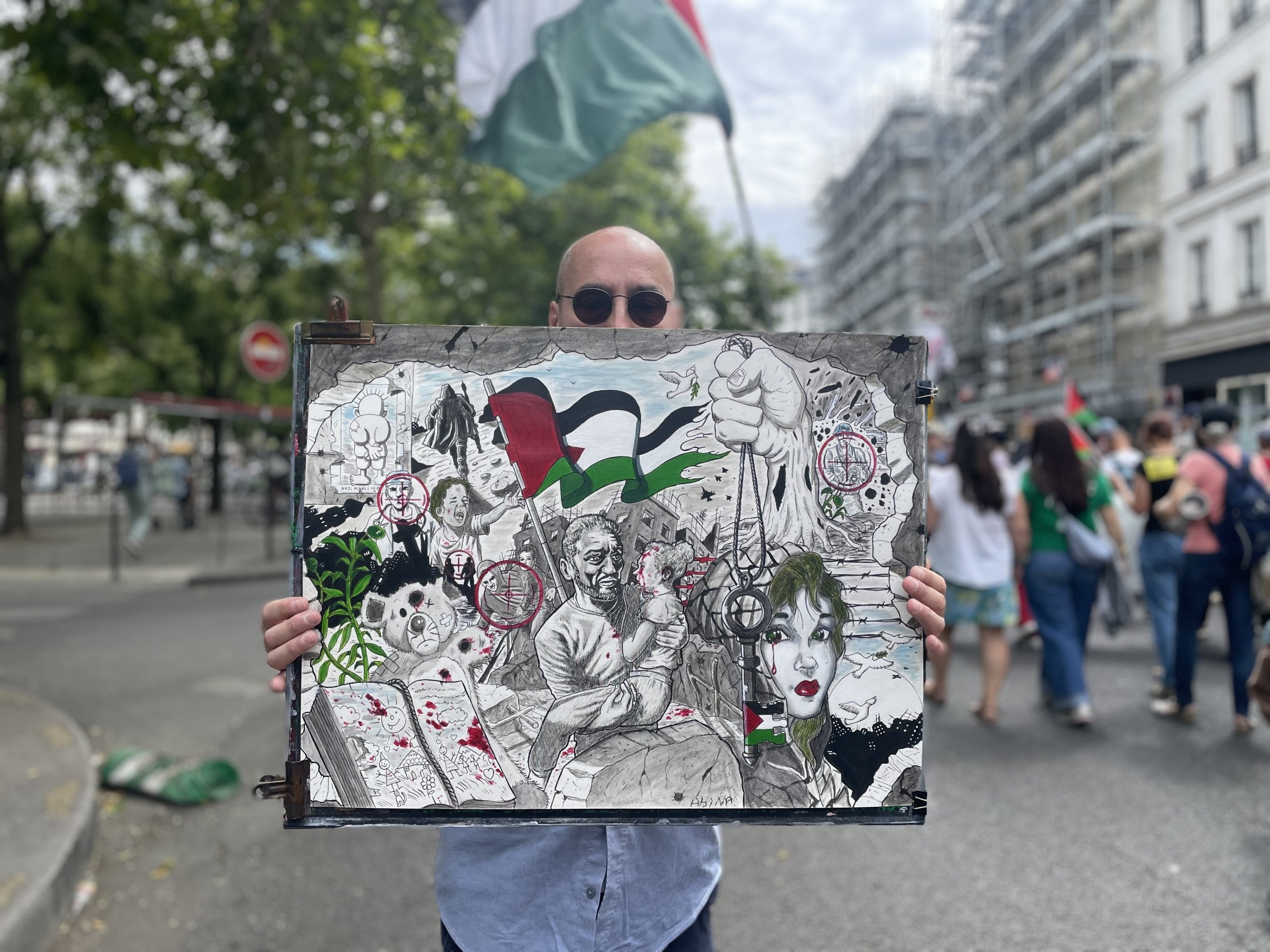 Algerian artist Aboulhak Abina showcases his paintings depicting the faces of Palestinian children killed by Israel, Paris, France, July 5, 2025. (AA Photo)