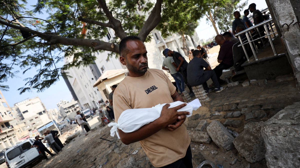 Adham carries the body of his nephew, six-week-old infant Yousef al-Safadi, who died of starvation according to health officials, Gaza City, Palestine, July 22, 2025. (Reuters Photo)