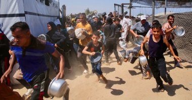 Palestinian children wait for a meal at a charity kitchen in the al-Mawasi area of Khan Younis, southern Gaza Strip, Palestine, July 22, 2025. (AFP Photo)