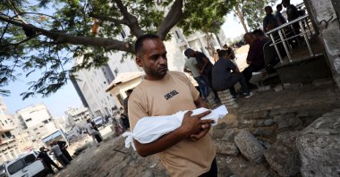 Adham carries the body of his nephew, six-week-old infant Yousef al-Safadi, who died of starvation according to health officials, Gaza City, Palestine, July 22, 2025. (Reuters Photo)