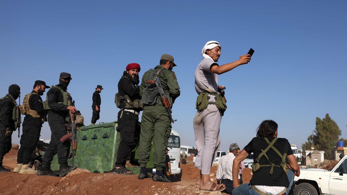 Syrian security forces stand by as a United Nations convoy evacuating families from Sweida moves through the buffer zone in Busra al-Harir in the southern Daraa province, Syria, July 22, 2025. (AFP Photo)