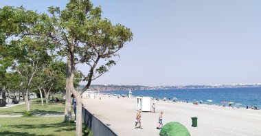 People spend time on the beach amid a heat wave across all the regions, Antalya, Türkiye, July 23, 2025. (DHA Photo)