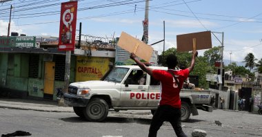 A man holds up placards as he yells toward a patrol car during a protest against gang-related violence and to demand the resignation of Haiti&#039;s transitional presidential council, Port-au-Prince, Haiti, May 15, 2025. (Reuters Photo)