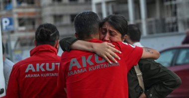 A grieving family member waits outside the Ankara Forensic Medicine Institute, embracing members of the AKUT Search and Rescue team while shedding tears, Ankara, Türkiye, July 24, 2025. (AA Photo)