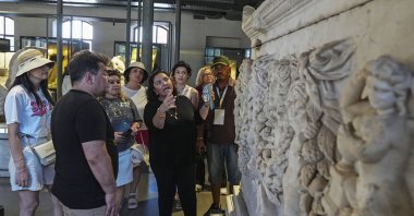 Foreign archaeologists closely examine an artifact while exploring Türkiye’s millennia-old cultural heritage in Izmir, Türkiye, July 23, 2025. (AA Photo)