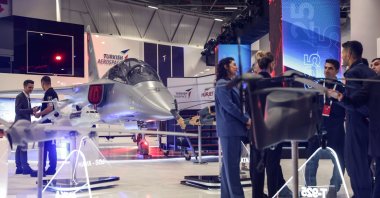 People stand in front of the Hürküş aircraft of the Turkish Aerospace Industries (TAI) during the International Defence Industry Fair (IDEF) in Istanbul, Türkiye, July 22, 2025. (EPA Photo)