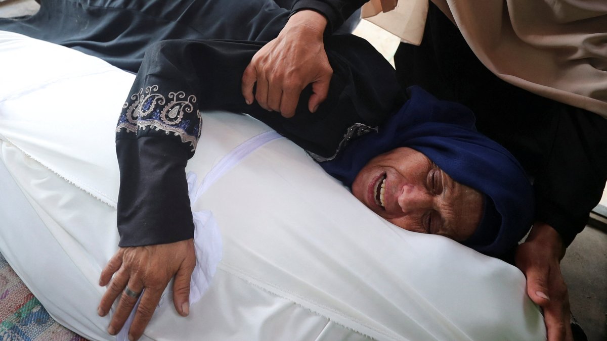A lady reacts as she holds a body at a funeral of Palestinians killed by Israeli fire while trying to receive aid and others who were killed in an overnight Israeli strike, according to medics, at Al-Shifa Hospital in Gaza City, July 26, 2025. (Reuters Photo)