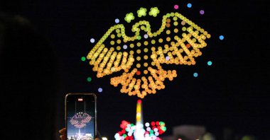 A Syrian woman takes a picture of the new national emblem of Syria, Damascus, Syria, July 5, 2025. (AFP Photo)