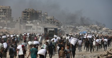 Palestinians living in tents due to hunger and forced displacement walk along Rashid Street toward the Zikim area to receive food aid, western Gaza, Palestine, July 27, 2025. (AA Photo)