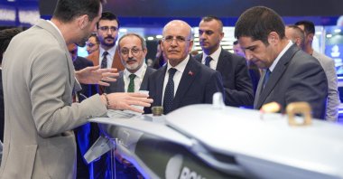 Treasury and Finance Minister Mehmet Şimşek (C) visits the booth of Turkish defense company Roketsan at the International Defense Industry Fair (IDEF) 2025, Istanbul, Türkiye, July 25, 2025. (AA Photo)