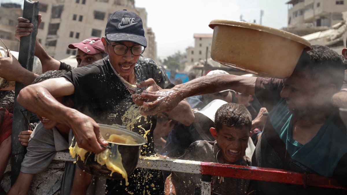 Palestinians react as they gather to receive food from a charity kitchen, in Gaza City, central Gaza, Palestine, July 28, 2025. (Reuters Photo)