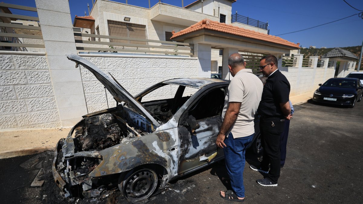 Locals inspect a burnt car in the Palestinian Christian village of Taybeh near the West Bank city of Ramallah, 28 July 2025. (EPA Photo)