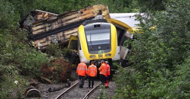 Employees of German rail operator Deutsche Bahn AG stand in front of a derailed train near Riedlingen, southwestern Germany, July 28, 2025. (AFP Photo)