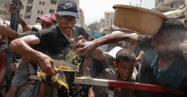Palestinians react as they gather to receive food from a charity kitchen, in Gaza City, central Gaza, Palestine, July 28, 2025. (Reuters Photo)