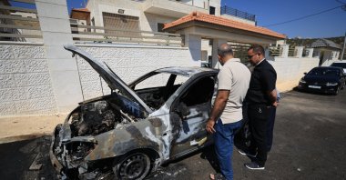 Locals inspect a burnt car in the Palestinian Christian village of Taybeh near the West Bank city of Ramallah, 28 July 2025. (EPA Photo)