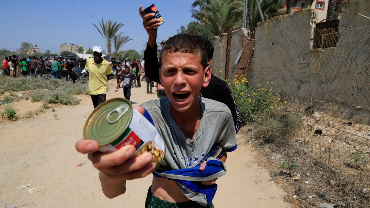 A Palestinian youth holds a can of chickpeas from an aid package dropped from an airplane, amid a hunger crisis, in Zawayda, central Gaza Strip, Palestine, July 28, 2025. (Reuters Photo)
