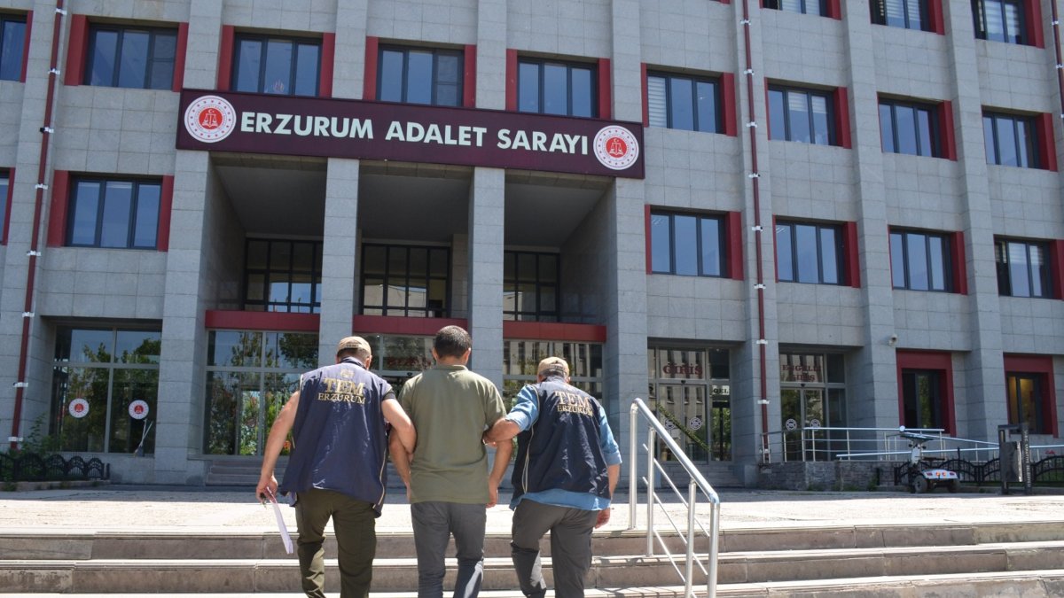 Two police officers escort a detained FETÖ suspect, Erzurum, eastern Türkiye, July 18, 2025. (AA Photo)