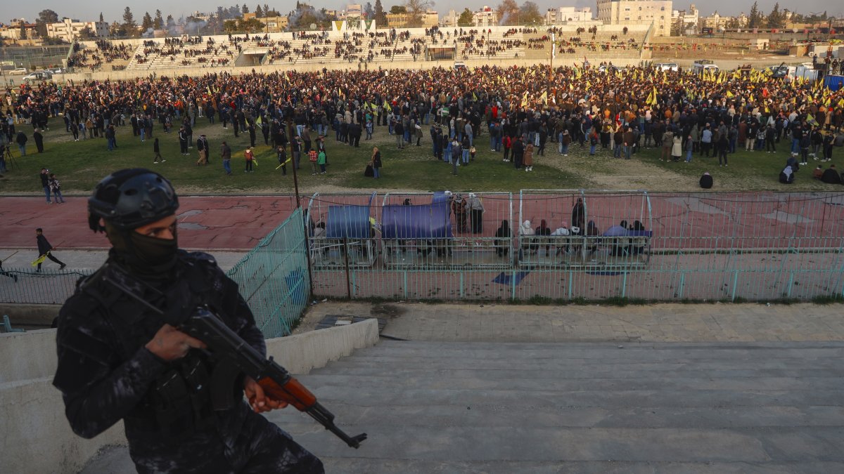 A YPG terrorist watches as hundreds attend a gathering to listen to a statement from the jailed leader of the PKK terrorist group, Qamishli, Syria, Feb. 27, 2025. (AP Photo)