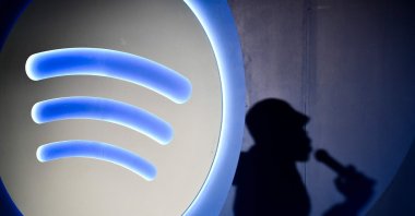 Spotify&#039;s Artificial Intelligence DJ announcer, Xavier X Jernigan&#039;s shadow, is pictured as he attends the presentation of the latest Spotify tool, Mexico City, Mexico, July 17, 2024. (AFP Photo)