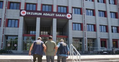 Two police officers escort a detained FETÖ suspect, Erzurum, eastern Türkiye, July 18, 2025. (AA Photo)