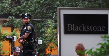 A police officer stands next to a logo of Blackstone, near the scene of a deadly mass shooting in Manhattan, New York City, U.S., July 29, 2025. (Reuters Photo)