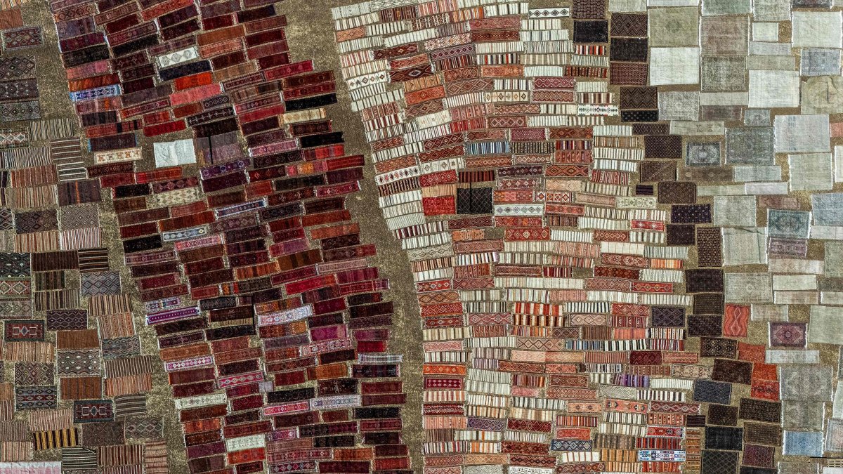 An aerial view shows handwoven carpets laid out in the open fields to soften their colours under the sizzling sun, Antalya, Türkiye, July 22, 2025.  (AFP Photo)