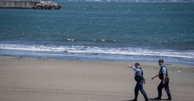 Police officers ask people to evacuate an empty beach due to a tsunami warning in Fujisawa city, Japan, July 30, 2025. (AFP Photo) 