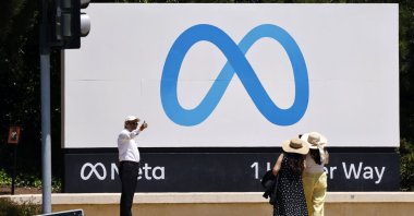 A person poses giving a thumbs up next to the Meta signage in front of the Meta Platforms headquarters, Menlo Park, California, U.S., July 29, 2025. (EPA Photo)