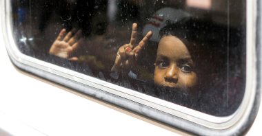 Sudanese boys gesture as they sit in a compartment of a special train arranged by the Egyptian government to carry families of Sudanese refugees returning home voluntarily, Cairo, Egypt, July 28, 2025. (AFP Photo)