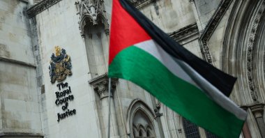 A person holds a Palestinian flag outside the High Court in London, U.K., July 21, 2025. (Reuters Photo)