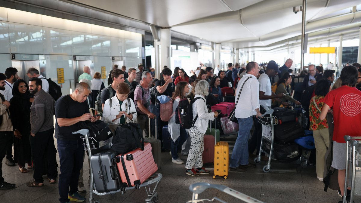 Passengers stand with their luggage after a radar failure led to the suspension of outbound flights across the U.K., at Heathrow Airport in Hounslow, London, U.K., July 30, 2025. (Reuters Photo)