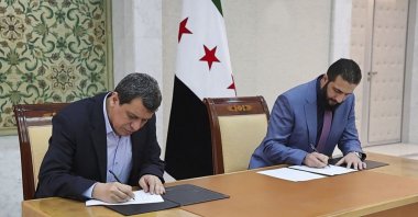 In this photo released by Syrian state news agency SANA, Syrian President interim Ahmad al-Sharaa (R) and YPG leader Ferhat Abdi Şahin sign a deal, Damascus, Syria, March 10, 2025. (AP Photo)