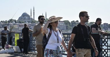 Tourists are photographed walking over Galata Bridge, Istanbul, Türkiye, June 9, 2025. (AA Photo)