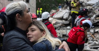Local residents comfort each other as Ukrainian rescuers work among the rubble of a destroyed residential building following an air attack in Kyiv, Ukraine, July 31, 2025. (AFP Photo)