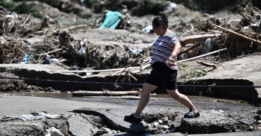 A woman walks past a flood-damaged area from heavy rains over the last few days in Huairou district, on the outskirts of Beijing, China, July 30, 2025. (AFP Photo)