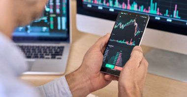 A crypto trader is seen using a smartphone in this stock photo. (Shutterstock Photo)