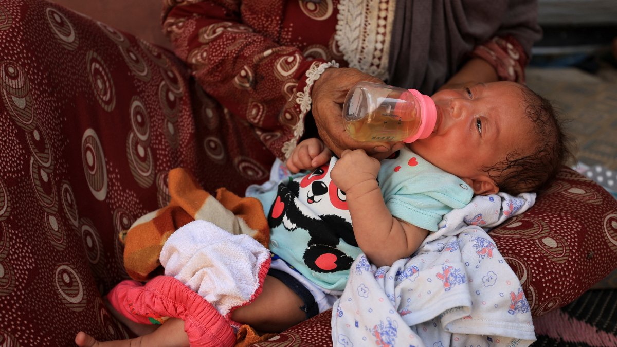 Nemah Hamouda holds her three-month-old granddaughter, Muntaha, in her arms while feeding her with a homemade herbal mixture, amid a severe shortage of infant formula and rising malnutrition, Gaza City, Palestine, July 29, 2025. (Reuters Photo)