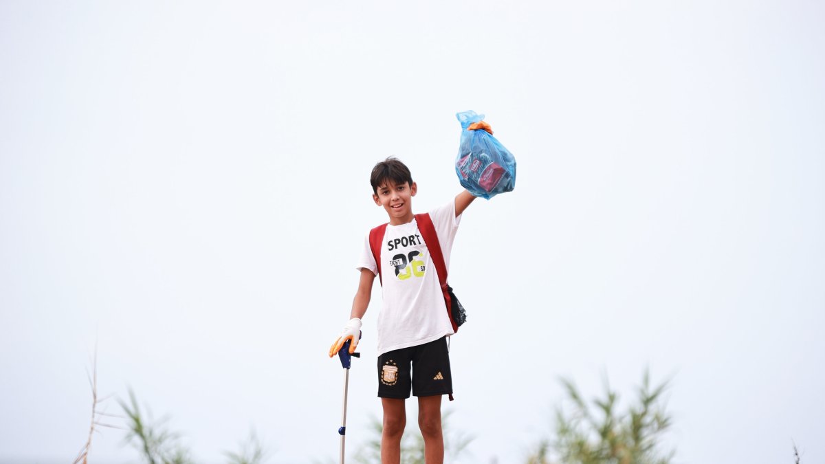 Aras Kayretli, 11, holds the trash he collected during his campaign called “I collect as much trash as my followers,” Mersin, Türkiye, Aug. 1, 2025. (AA Photo)