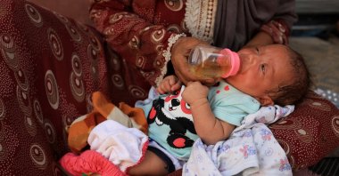 Nemah Hamouda holds her three-month-old granddaughter, Muntaha, in her arms while feeding her with a homemade herbal mixture, amid a severe shortage of infant formula and rising malnutrition, Gaza City, Palestine, July 29, 2025. (Reuters Photo)