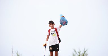 Aras Kayretli, 11, holds the trash he collected during his campaign called “I collect as much trash as my followers,” Mersin, Türkiye, Aug. 1, 2025. (AA Photo)