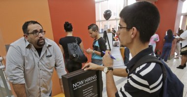 Job applicant Lazaro Fonte, right, 24, of Miami, talks with Banana Republic assistant manager Edward Ortega, during a job fair at Dolphin Mall in Miami, Oct. 6, 2015. (AP File Photo)