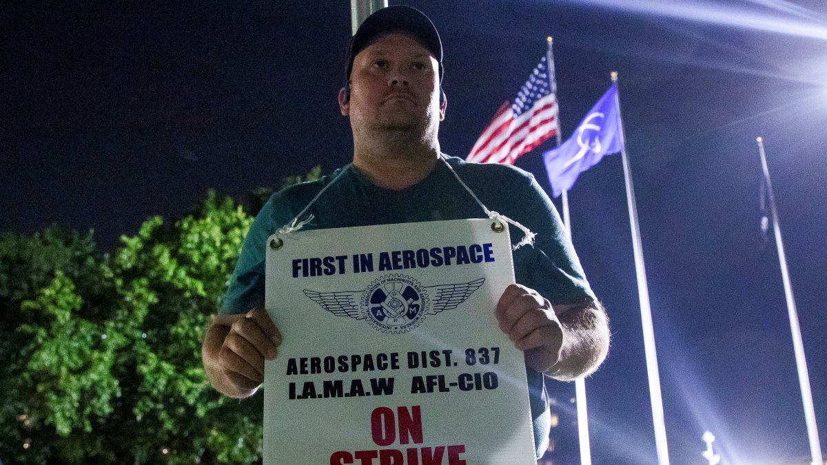 A worker holds a picket sign, as people protest during a walkout by members of the International Association of Machinists and Aerospace Workers (IAM) over contract negotiations, outside a Boeing facility, Berkeley, Missouri, U.S., Aug. 4, 2025. (Reuters Photo)