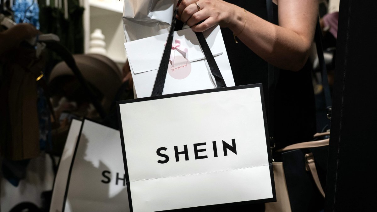 A customer holds her bags as she exits a pop-up store of the Chinese-founded fast fashion brand Shein, Dijon, France, June 26, 2025. (AFP Photo)